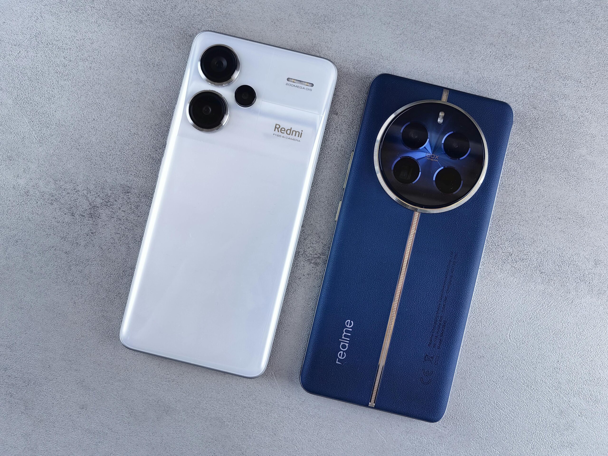 Two smartphones, one white and one blue, displayed on a textured grey background.